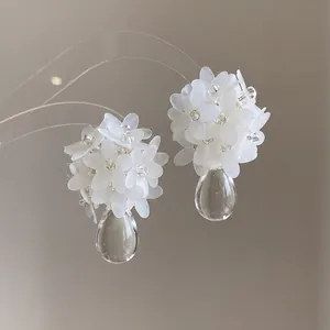 Elegant white floral cluster earrings with clear teardrop pendants for a fairy-like look.