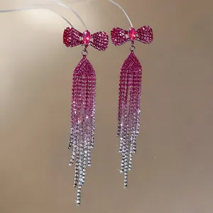 Macro view of elegant bowknot earrings featuring purple gradient rhinestone fringe tassels