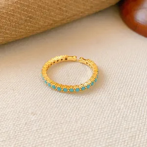 Detailansicht eines 18k vergoldeten offenen Rings mit türkisfarbenen Zirkonia-Steinen