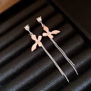 Dettaglio di orecchini a nappa in argento con farfalla rosa e cristalli scintillanti