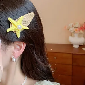 Detail shot of a bohemian starfish hair clip with a white pearl on a woven base