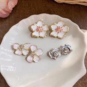 Elegant French style oil drop flower stud earrings set on a white shell-shaped plate