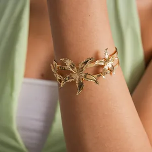 Elegant gold metal starfish arm cuff bracelet shown on arm for detailed accessory view