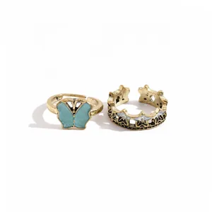 Vintage gold-toned two-piece ring set featuring a blue butterfly and star crown pattern