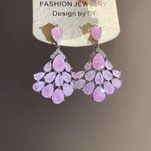 Vue macro détaillée de boucles d'oreilles pendantes en zircon rose plaqué or 14 carats
