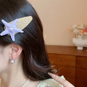 Close-up of a purple bohemian starfish hair clip with pearl detail on a model's hair