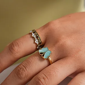 Close-up of vintage butterfly and star rings set on a finger for jewelry detail