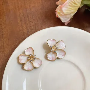 Detailed view of elegant French style enamel flower stud earrings with crystal centers.