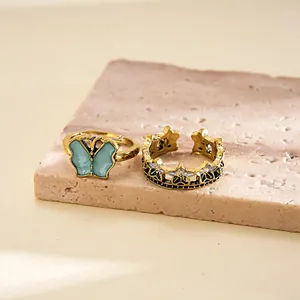 Detailed view of vintage gold ring set featuring blue butterfly and star crown designs