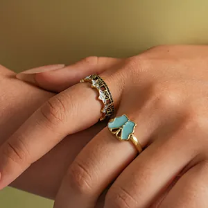 Macro detail of a two-piece set featuring vintage butterfly and star open rings on a hand