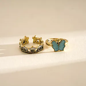 Detailed macro shot of vintage gold butterfly and star patterned adjustable open rings.