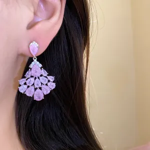 Détail de boucles d'oreilles en zircon rose plaquées or 14 carats portées à l'oreille