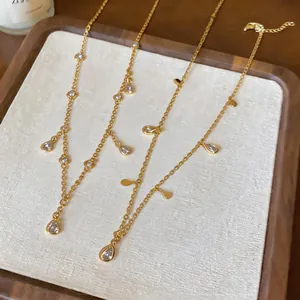 Dettaglio di collane in oro a strati con pendenti in zircone a forma di goccia d'acqua