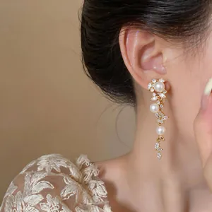 Orecchini pendenti con perle e zirconi a forma di spiga dettaglio indossato da modella