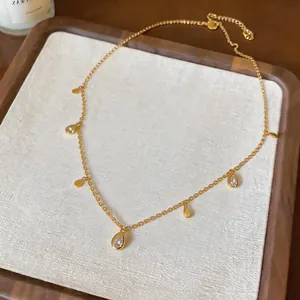Vista dettagliata della collana dorata minimalista con ciondoli a goccia in zirconia.