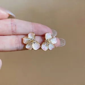 Close-up of elegant French style pink enamel flower stud earrings with crystal center
