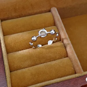 Elegant silver-toned open ring with a clear round zircon, set in a tan velvet box.