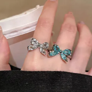 Vista detallada de dos anillos de mariposa con circonitas transparentes y azules
