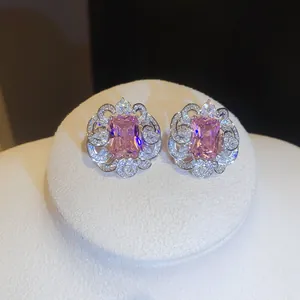 Close-up of elegant square pink zircon stud earrings with intricate floral pavé-set detail.