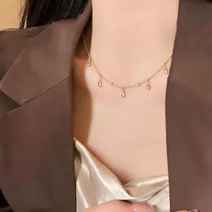 Dettaglio di una collana dorata con scintillanti ciondoli in zirconia a goccia.