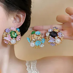 Detailed view of vintage palace style oil-drop pearl and butterfly flower stud earrings