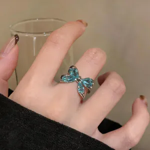 Vista detallada de un elegante anillo de mariposa plateado con piedras de circonita azul