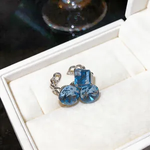Detalle de un anillo de mariposa con circón azul francés dentro de una caja de regalo
