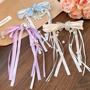 Elegant rhinestone ribbon bow hair clips with tassels in blue, purple, and cream.