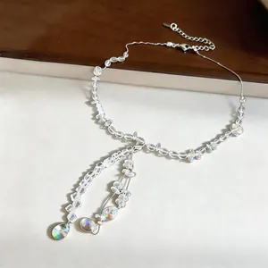 Close-up of heart pendant crystal beaded necklace with iridescent droplets.