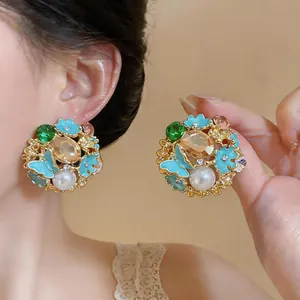 Detailed close-up of vintage court style enamel butterfly flower earrings with pearls