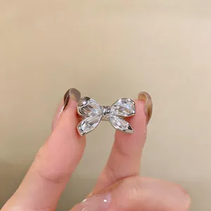 Primer plano de un elegante anillo de lazo plateado con circonitas brillantes y finas