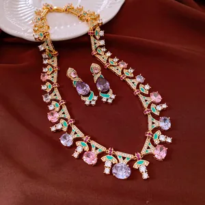 Detailed view of a vintage jewelry set with pink and purple zircons and green enamel.