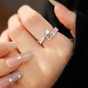 Close-up of a minimalist silver open ring featuring sparkling zircons and resin details.