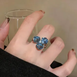Detalle de un elegante anillo de mariposa con circón azul en el dedo para un look chic