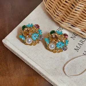 Detailed view of vintage palace-style earrings with turquoise enamel flowers and pearls.