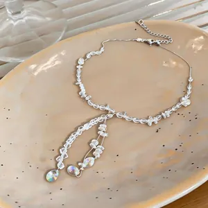 Close-up detail of a handmade clear crystal beaded necklace with iridescent teardrop pendants