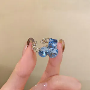 Primer plano de un anillo de cadena plateado con brillantes circonitas azules.