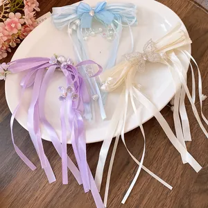 Close-up of elegant rhinestone ribbon bow hair clips with long tassels in various colors