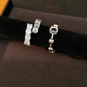 Close-up detail of silver open ring featuring zircon rows and dark resin center element