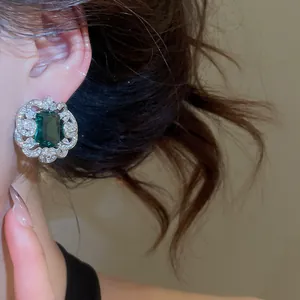 Detailed macro view of a luxury emerald square earring with sparkling zircon floral scalloped border