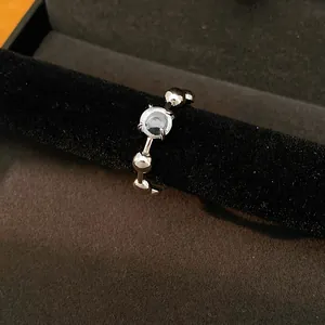 Detailed view of a minimalist silver-toned ring with a brilliant round clear stone