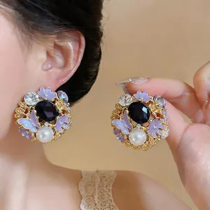 Exquisite close-up detail of vintage purple enamel butterfly flower earrings with pearl