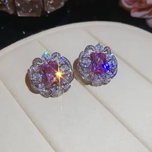Close-up of luxurious square pink zircon stud earrings with intricate silver floral lace
