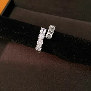 Close-up of elegant open ring with five sparkling zircons and dark resin inlay
