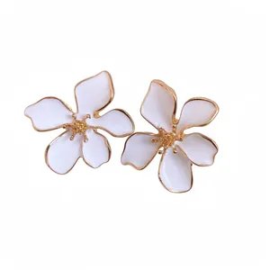 Elegant white enamel flower stud earrings with gold trim and textured center