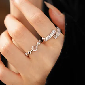Detailed close-up of minimalist silver open rings featuring zircon stones and round resin detail