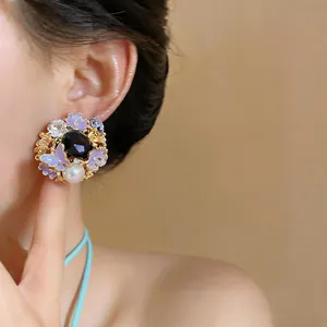 Macro detail of vintage court style earrings featuring purple butterflies and pearls