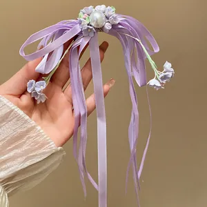 Macro view of an elegant purple ribbon bow hair clip with pearl and floral details