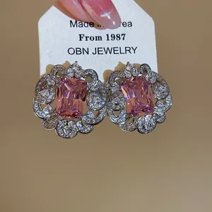 Detail view of luxury square pink zircon earrings with ornate micro-pave lace border.