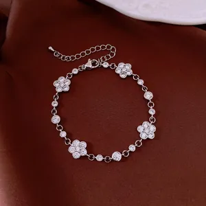 Elegant silver flower bracelet with sparkling cubic zirconia on burgundy silk background